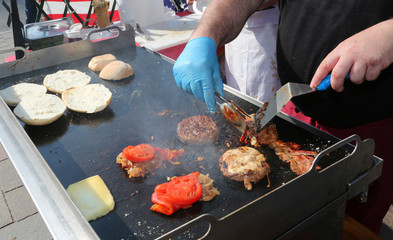 On the stand of street food there is a chef with blue gloves coo - obrazy, fototapety, plakaty
