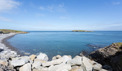 Fototapeta na wymiar Rocky coastline at Moelfre, Anglesey in North Wales with distant view of Moelfre Island (Ynys Moelfre)