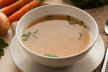 Bone broth made from chicken, served in a bowl with parsley