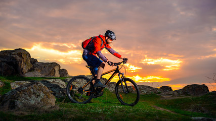 Fototapeta na wymiar Cyclist Riding Mountain Bike on the Spring Rocky Trail at Beautiful Sunset. Extreme Sports and Adventure Concept.