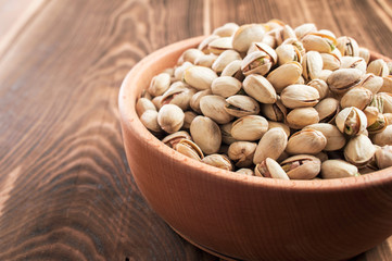 wooden plate with pistachios on a table