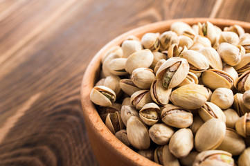 pistachios in a bowl on wooden table