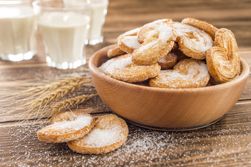 cookies on the table sprinkled with sugar and milk in a glass