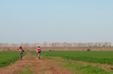 two girls are traveling on bicycles