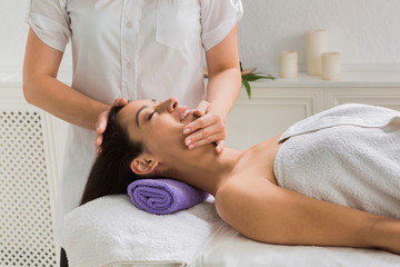 Fototapeta na wymiar Woman massagist make face lifting massage in spa wellness center