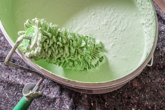 Farbwalze mit gr&uuml;ner Farbe bei Renovierungsarbeiten