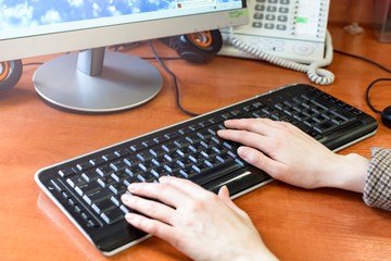 Obraz na płótnie Canvas Female office worker, typing on a keyboard