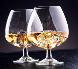 glass of whiskey with ice on a wooden