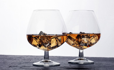 glass of whiskey with ice on a wooden