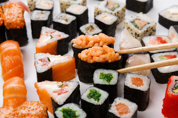 Set of sushi, maki and rolls isolated closeup with chopsticks