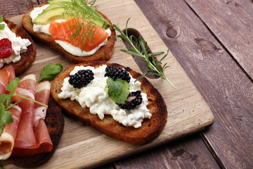 Bread Brushetta or authentic traditional spanish tapas set for lunch table. Sharing antipasti on party or summer picnic time over wooden rustic background.