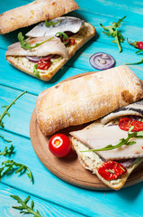 sandwich with herring and onion on blue wooden table