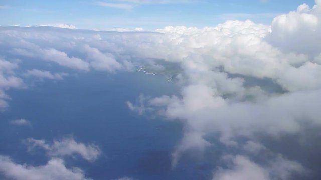 Aerial footage flying over Maui Hawaii and Pacific Ocean on partly cloudy day.