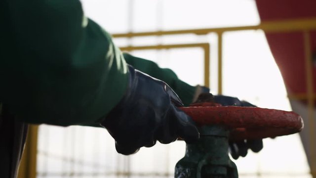 Closeup Worker in Leather Gloves Twists Iron Valve
