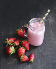 Strawberry smoothie with fresh strawberries on a wooden table