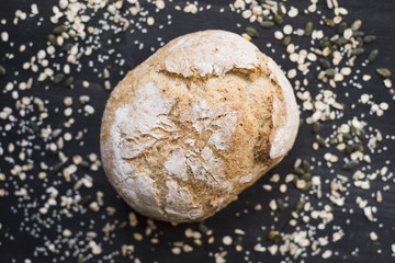 Bread with oats and seeds on a dark wooden table