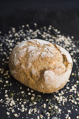 Bread with oats and seeds on a dark wooden table