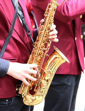 player plays the saxophone in the brass bas outside