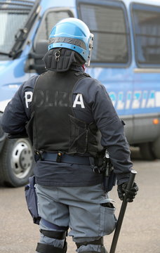 police in riot gear with blue helmet and truncheon in Itay