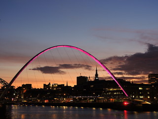 Fototapeta na wymiar Newcastle upon Tyne, England, United Kingdom. The Gateshead Millennium Bridge and its colors durind evening time