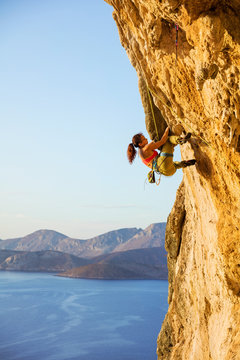 Young woman climbing challenging route