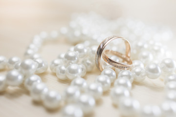 A pair of gold wedding rings on pearls