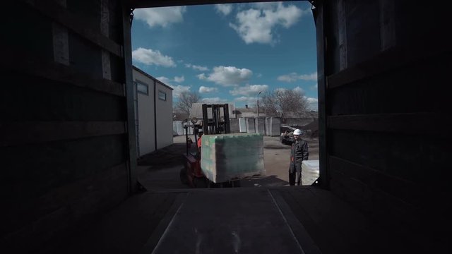 The cargo is being loaded to the truck with the vehicle.