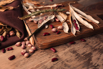 Beans with pods on wooden cutting board