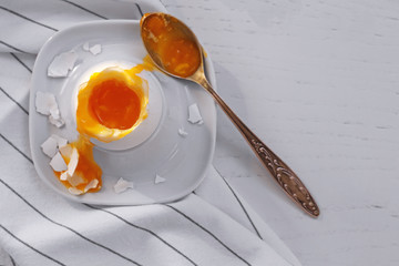 Holder with soft boiled egg on table