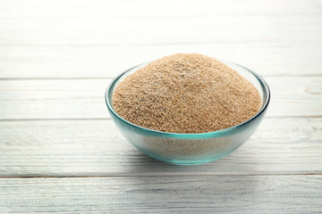 Small bowl of bread crumbs on wooden background