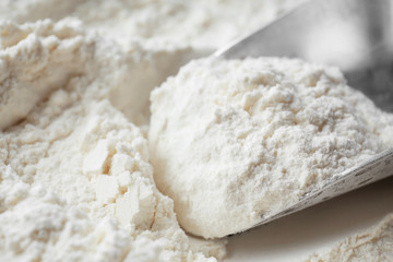Fototapeta na wymiar Metal scoop in flour, closeup