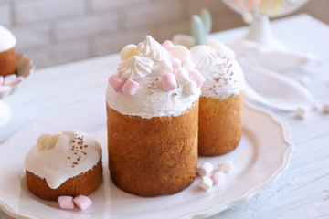 Beautiful plate with traditional Russian Easter cakes on wooden table