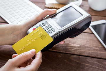 Payment for breakfast with card and terminal on wooden table background