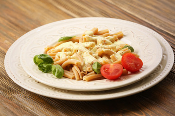 Portion of delicious pasta with cheese on wooden background