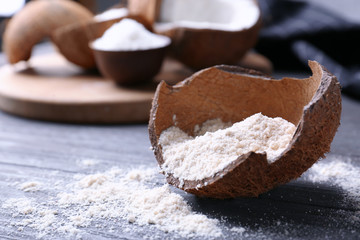 Coconut flour in rind on wooden table