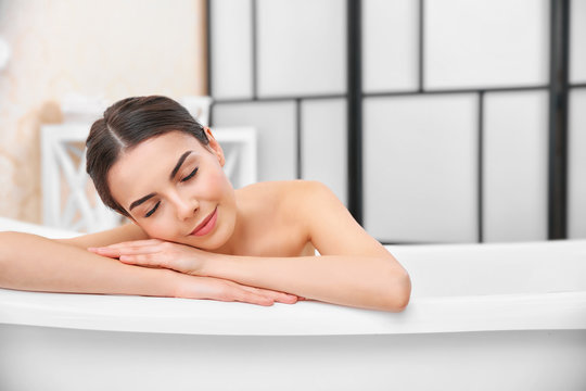 Beautiful young woman taking bath at home