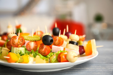 Plate with delicious canape setting on blurred background
