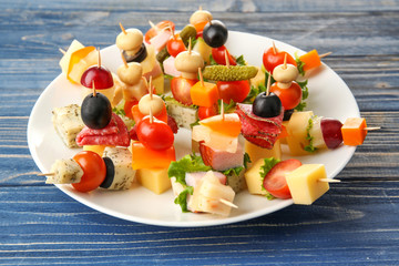 White plate with delicious canape setting on wooden background
