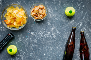 TV control, snacks, beer on dark background top view space for text