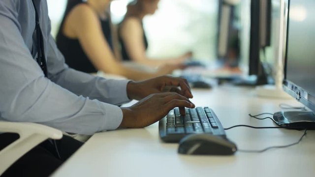  Close up on hands of unrecognizable worker working on computer in city office