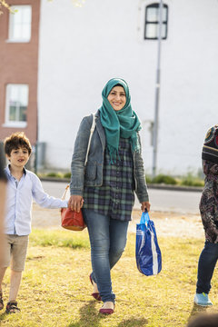 Sweden, Blekinge, Solvesborg, Young woman and boy (6-7) walking holding hands
