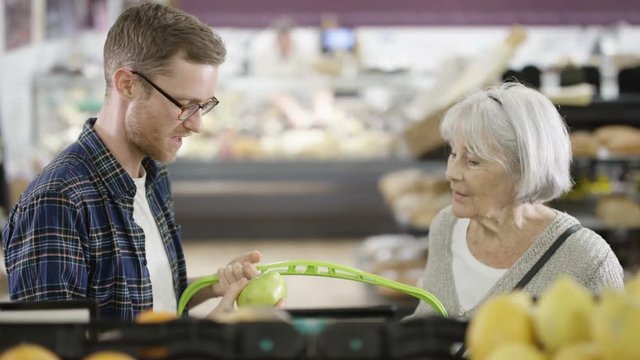  Senior lady & her adult grandson buying groceries in the supermarket