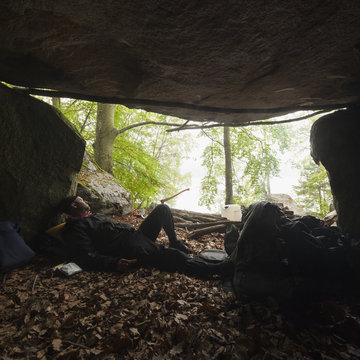 Sweden, Blekinge, Halen, Man lying down in cave