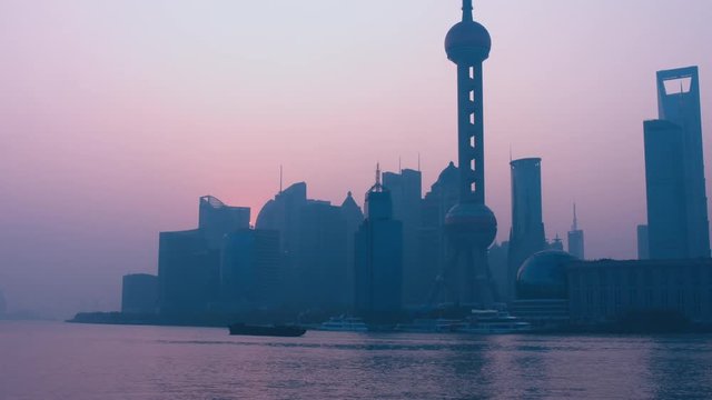 Ships passing Shanghai central business district over Huangpu river. Morning shot, sunrise. 4K UHD