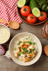 Delicious rice with chicken in bowl on table