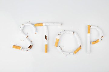 Word STOP made of cigarettes on white background