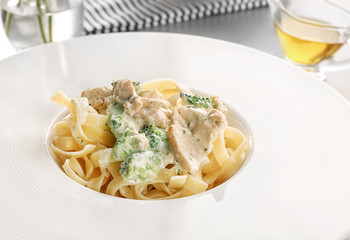 Delicious pasta alfredo with chicken on plate, closeup