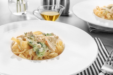 Plate of delicious pasta alfredo with chicken on table
