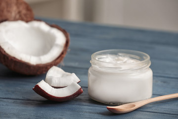 Fresh coconut oil in glassware with spoon on wooden table