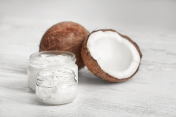 Fototapeta na wymiar Fresh coconut oil and nuts on wooden background